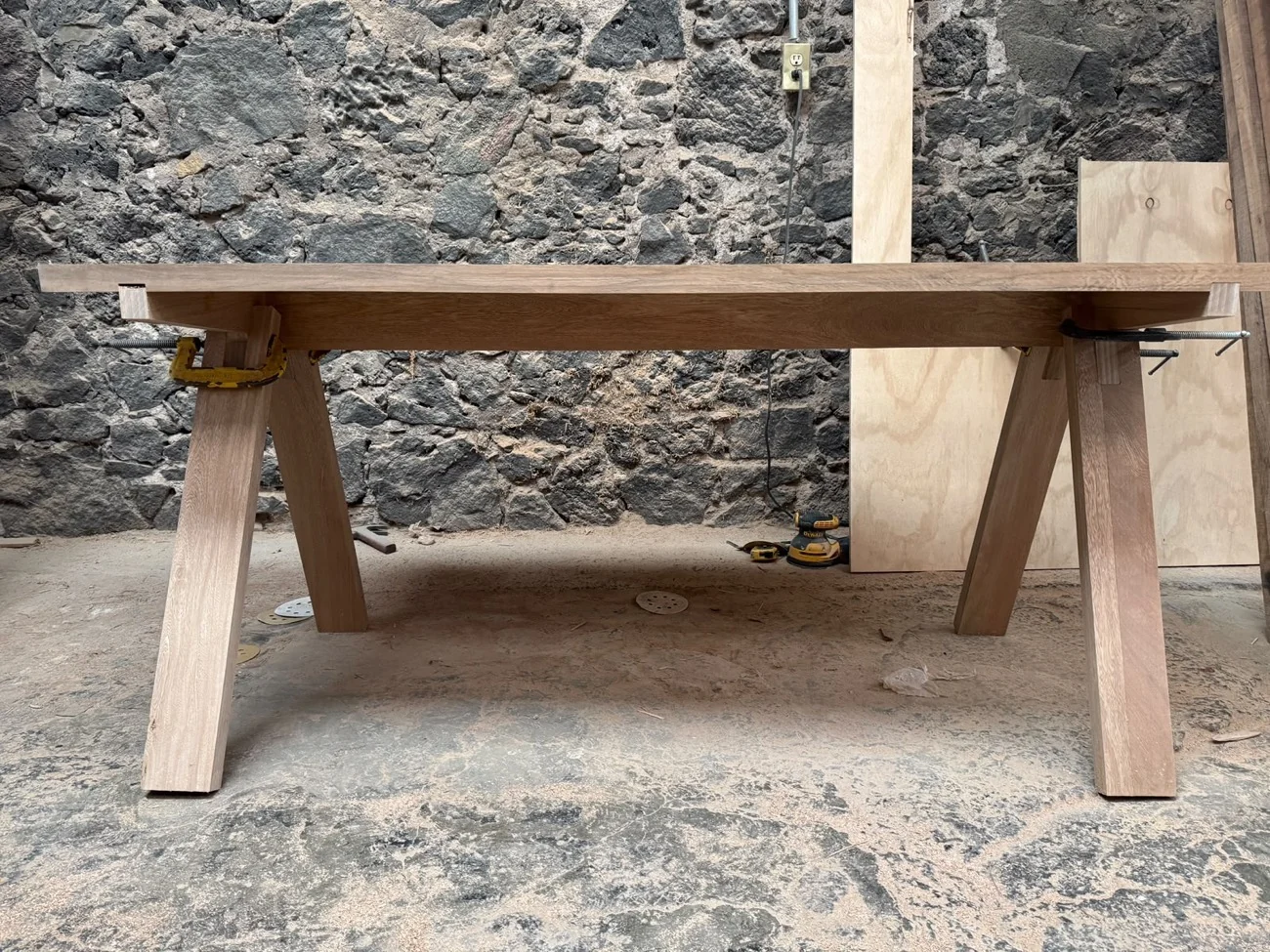 Mesa de madera en proceso de ensamble, con sus patas y uniones a la vista